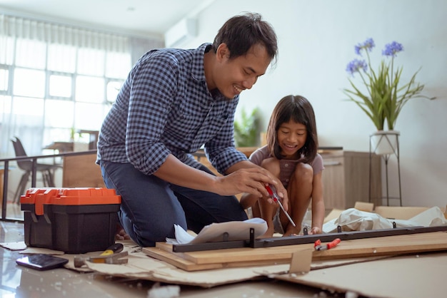 Padre e hija armando muebles de autoensamblaje