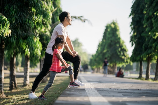 Padre e hija asiáticos estiramientos y deporte al aire libre