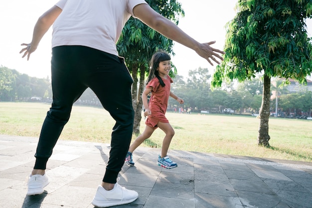 Padre e hija asiáticos hacen ejercicios para atrapar y jugar juntos