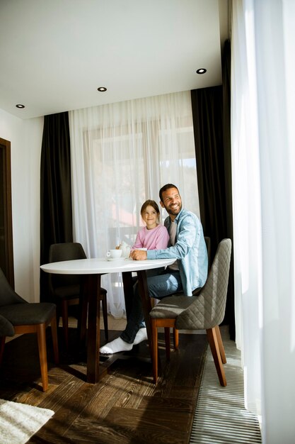 Padre e hija bebiendo té juntos en la sala de estar