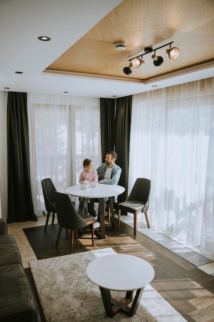 Padre e hija bebiendo té juntos en la sala de estar