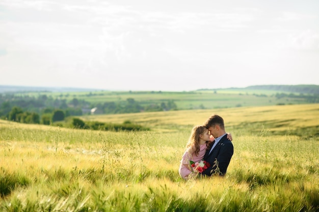 Padre e hija en un campo de trigo verde.