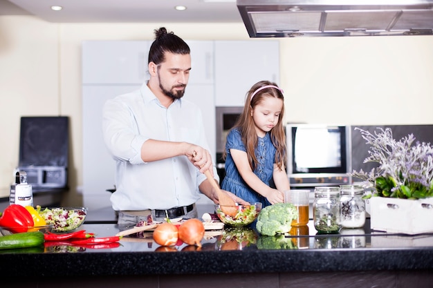 Padre e hija cocinando comida en la cocina juntos