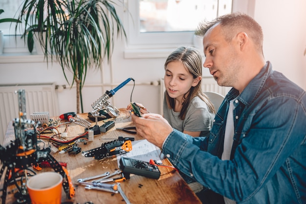 Padre e hija construyendo robot