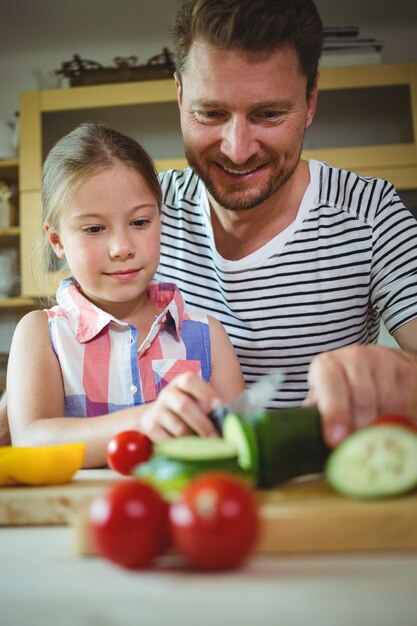 Padre e hija cortando verduras en la cocina