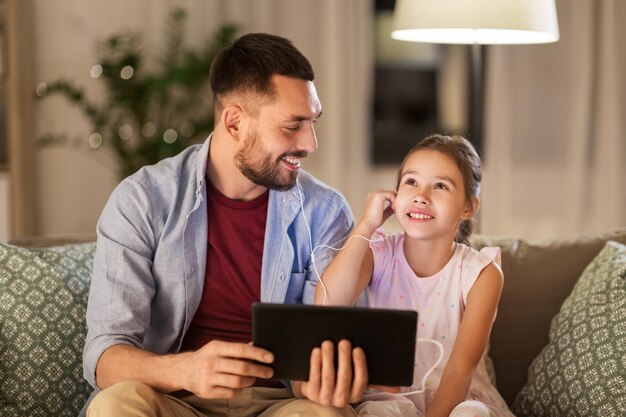 padre e hija escuchando música en la tableta