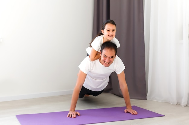 padre e hija hacen fitness en casa, entrenamiento deportivo