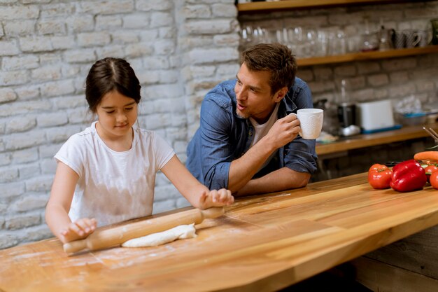 Padre e hija haciendo pan en la cocina.