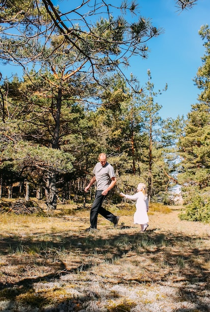 Padre e hija jugando en un bosque de primavera Las personas activas se divierten al aire libre