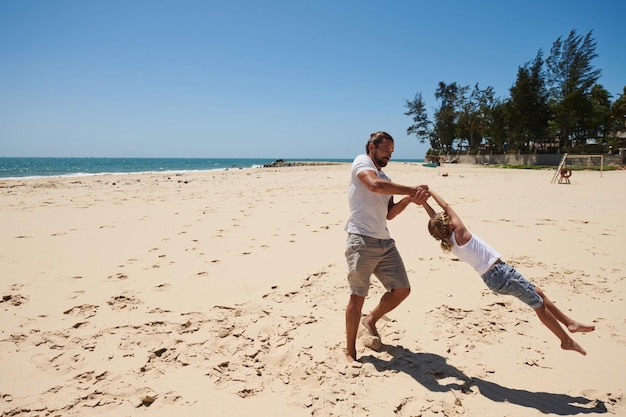 padre e hija jugando en la playa