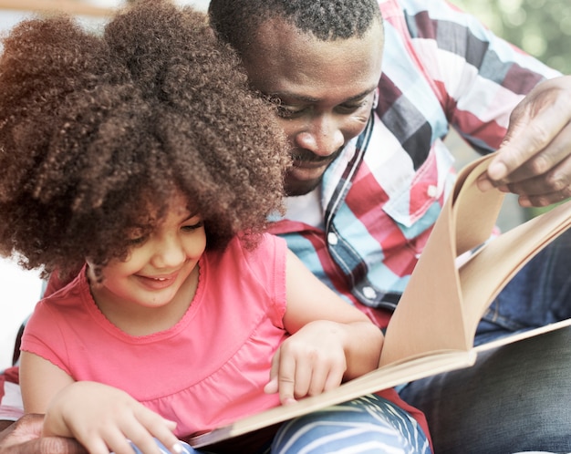 Padre e hija leyendo un libro juntos