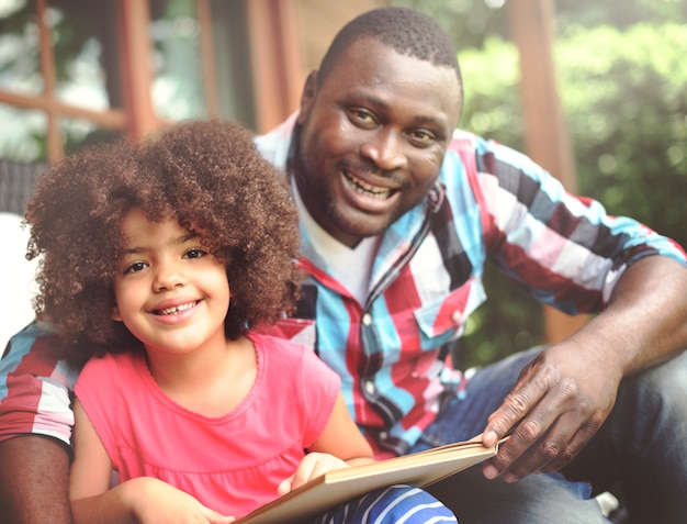 Padre e hija leyendo un libro juntos