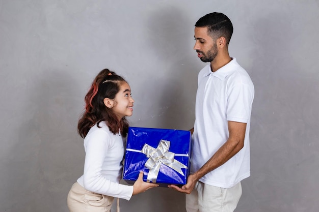 Padre e hija negros de fondo gris con un regalo del día del padre