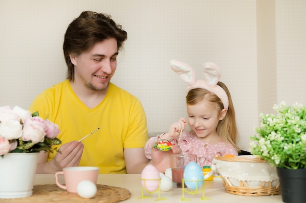 Padre e hija pintando huevos de Pascua