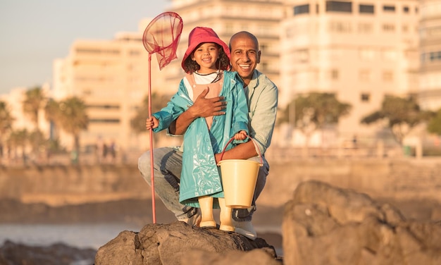 Padre e hija y retrato de pesca con un hombre y un niño en unas vacaciones en el océano para vincularse con amor Red de pesca y balde con un padre y una niña relajándose juntos para pescar en unas vacaciones junto al mar