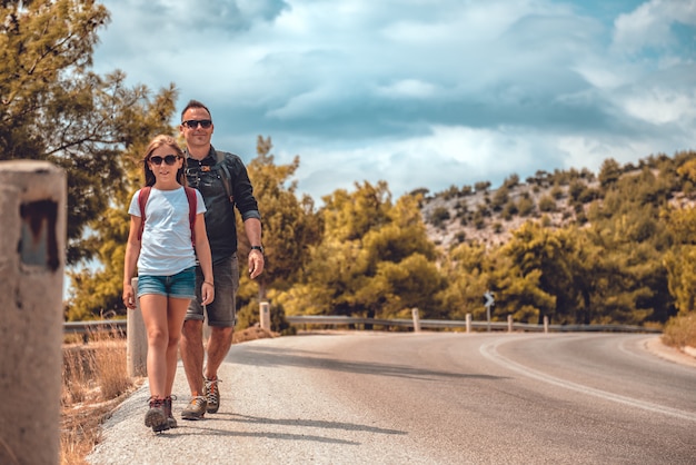 Foto padre e hija, senderismo en la carretera de montaña