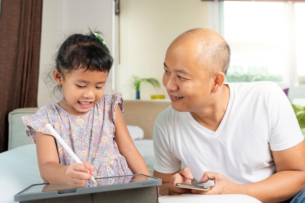 padre e hija, sentado, en, sofá, utilizar, tableta