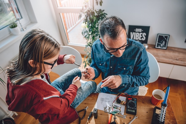 Padre e hija trabajando juntos en taller