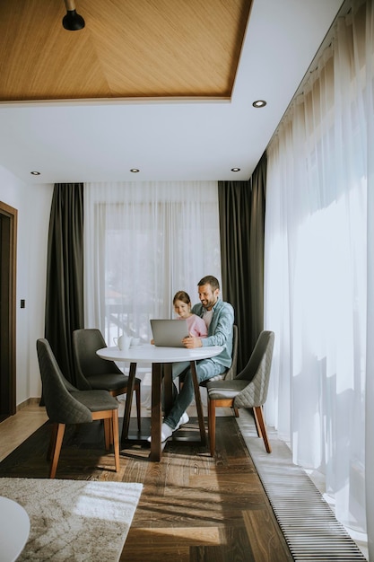 Padre e hija usando una computadora portátil juntos en la habitación