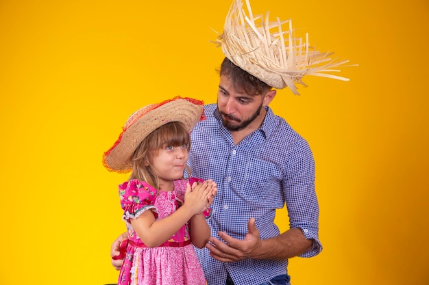 Padre e hija vestidos con ropa de fiesta de junio Papá joven e hija pequeña listos para la fiesta de junio Espacio de copia