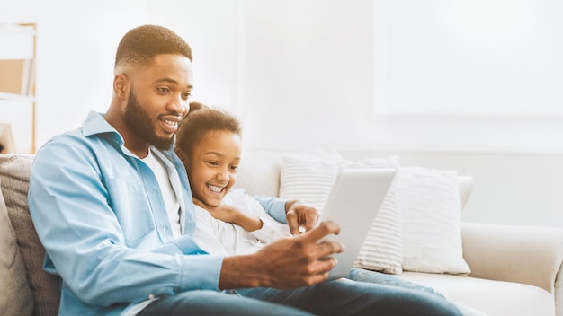 Padre e hija viendo una película en la tableta