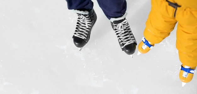 Padre e hijas zapatos de patinaje closeup sobre el fondo de una pista de hielo.