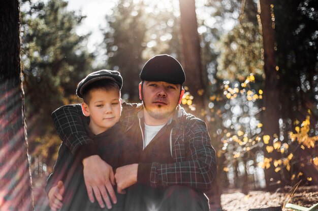 Padre e hijo abrazándose en el parque de otoño con poca profundidad de campo Vacaciones familiares activas