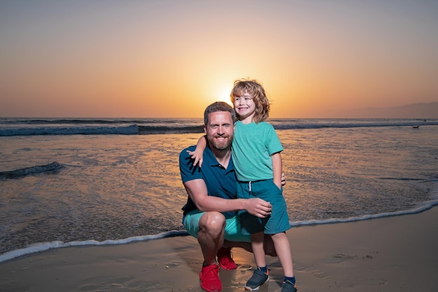 Padre e hijo abrazándose en la playa durante la puesta de sol