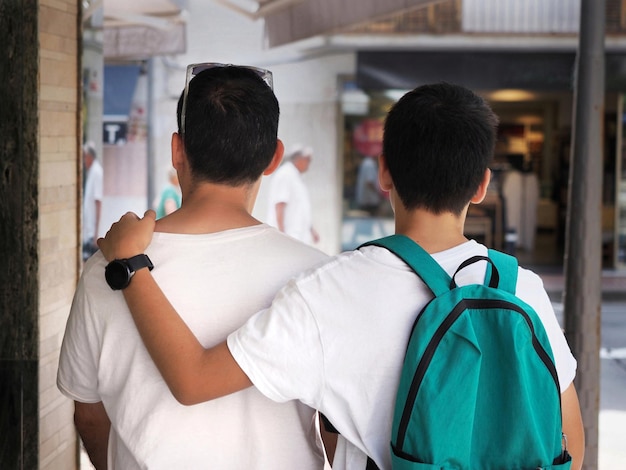 Padre e hijo adolescente caminando juntos vista posterior