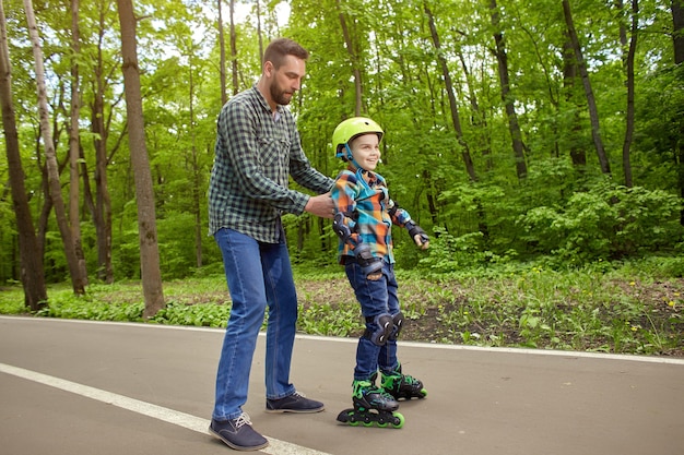 Padre e hijo al aire libre, preparándose para patinar