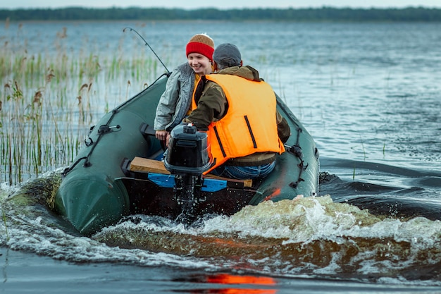 Padre e hijo andan en bote a motor por el lago.