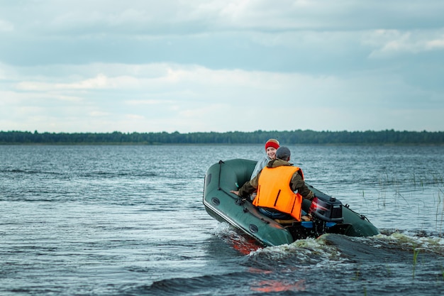 Padre e hijo andan en bote a motor por el lago.