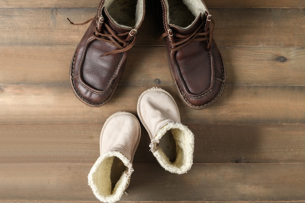 Padre e hijo botas de cuero marrón zapatos sobre superficie de madera