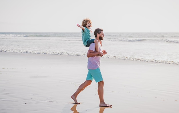 Padre e hijo caminando en el mar guapo padre con niño hijo padre feliz sosteniendo niño papá