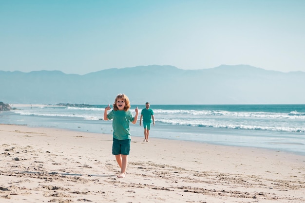 Padre e hijo caminando en la playa puesta de sol familia en el mar