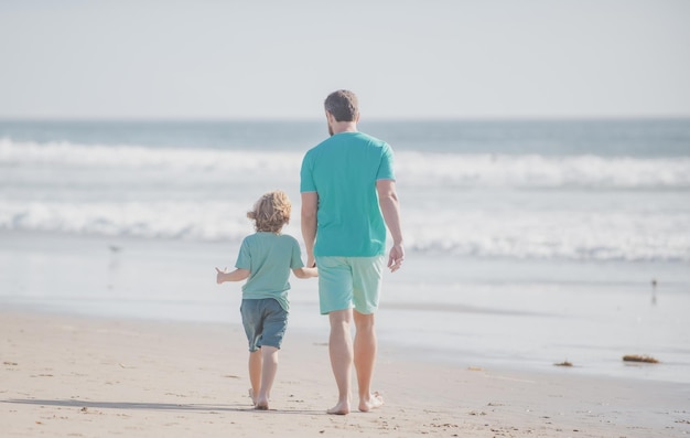 Padre e hijo caminando en la playa de verano Concepto de familia amistosa y de vacaciones de verano