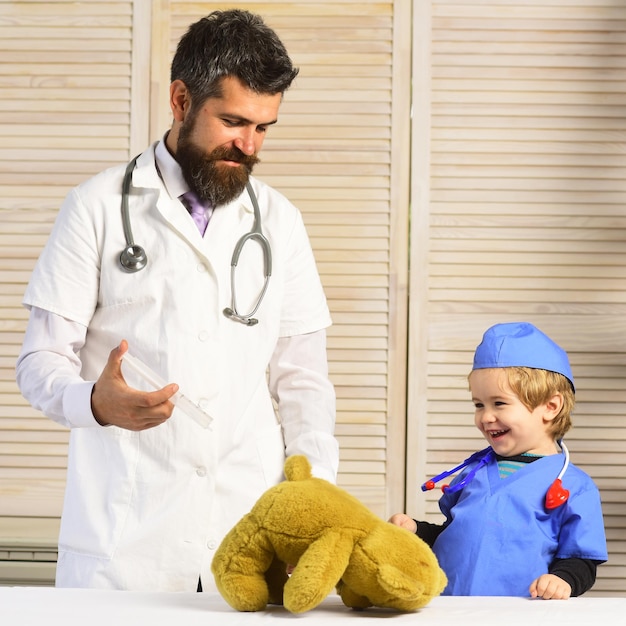 Padre e hijo con caras sonrientes jugando al doctor