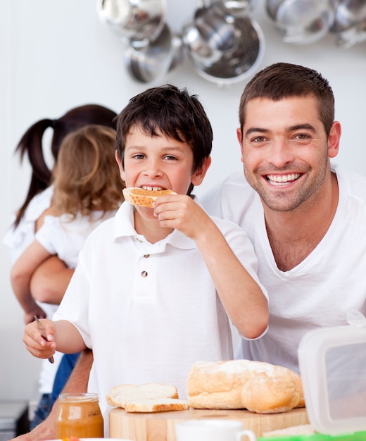 Padre e hijo, comer un brindis en la hora del desayuno