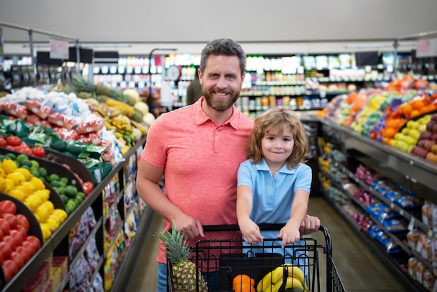 Padre e hijo compran verduras frescas en el supermercado Familia en la tienda