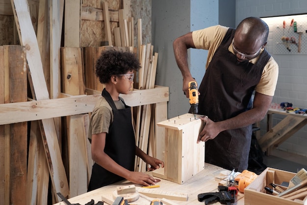 Padre e hijo construyendo casita para pájaros