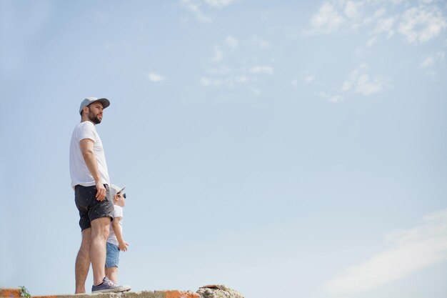 Padre e hijo contra el fondo del cielo azul Copiar espacio con papá e hijo y cielo