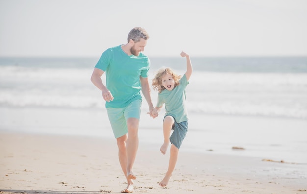 Padre e hijo corriendo en la playa de verano Papá e hijo disfrutando al aire libre