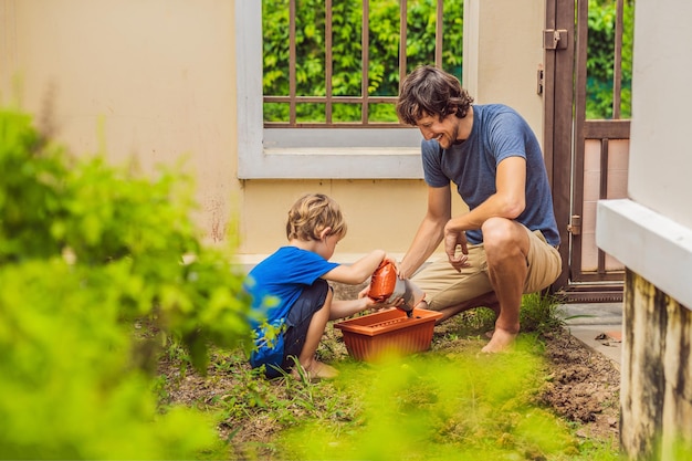 Foto padre e hijo cultivando un huerto en el jardín cerca de la casa