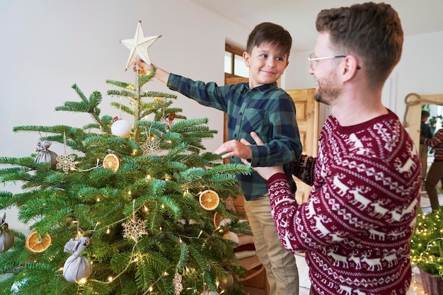 Padre e hijo decorando el árbol de Navidad