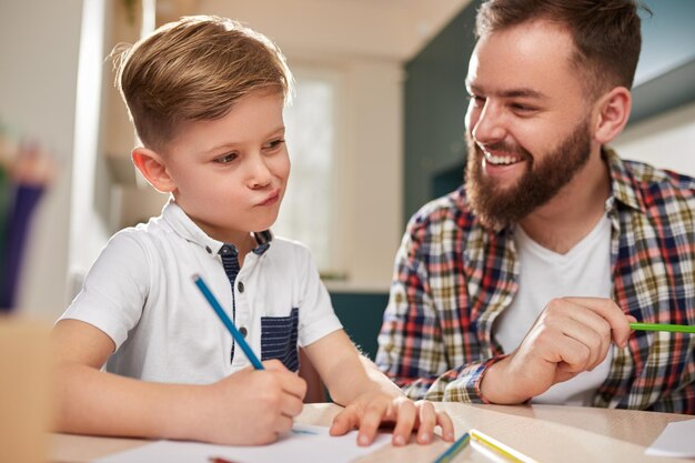 Padre e hijo dibujando juntos en casa