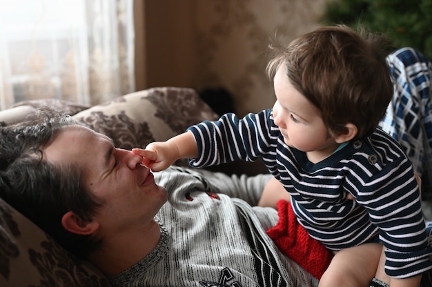 Padre e hijo se divierten. Padre solo en casa con un niño jugando juntos.