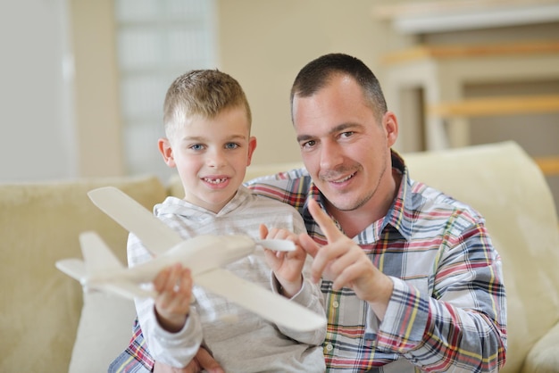 padre e hijo ensamblando un avión de juguete en la moderna sala de estar interior