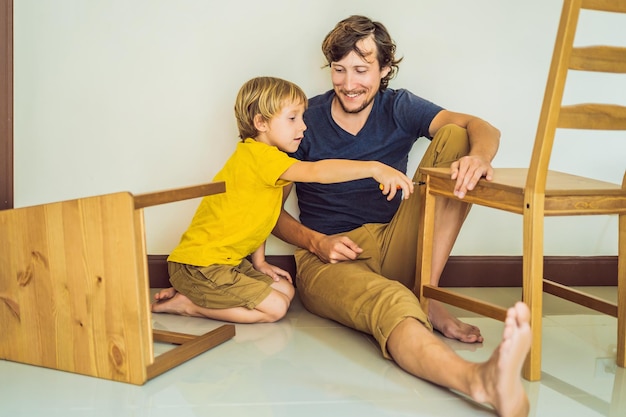 Padre e hijo ensamblando muebles Niño ayudando a su padre en casa Concepto de familia feliz