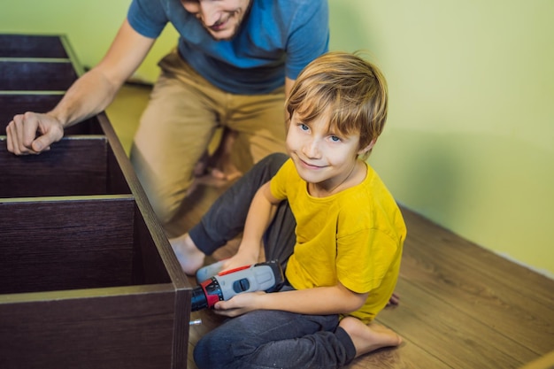 Padre e hijo ensamblando muebles Niño ayudando a su padre en casa Concepto de familia feliz