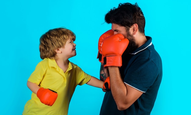 Padre e hijo durante el entrenamiento de boxeo. Papá e hijo con guantes de boxeo. Actividad infantil. Haciendo ejercicio juntos.